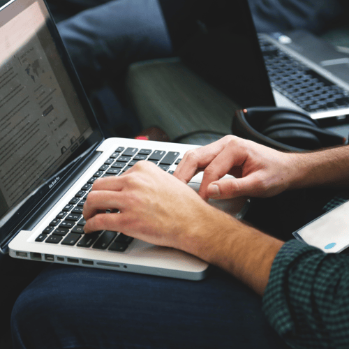 Close-up image of someone typing on a laptop